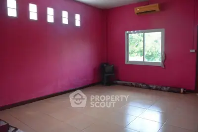 Spacious room with vibrant pink walls and large window offering natural light.
