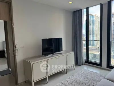 Modern living room with TV and city view through large windows.