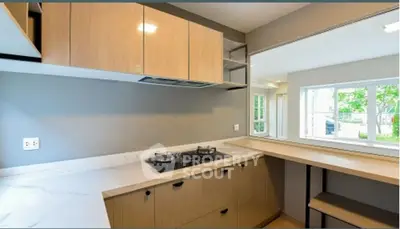 Modern kitchen with sleek cabinetry and gas stove, open layout with natural light.