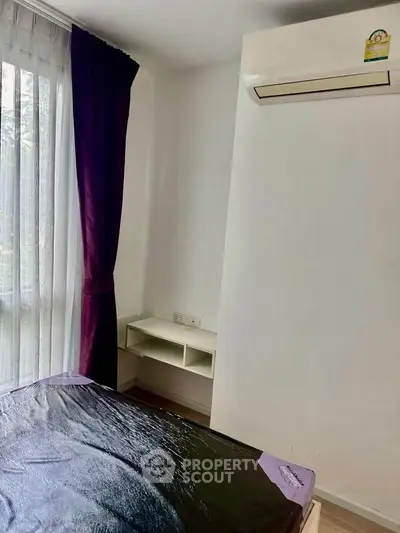 Cozy bedroom with air conditioning and large window with purple curtains