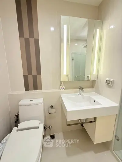 Modern bathroom with sleek fixtures and elegant design, featuring a stylish sink and toilet.