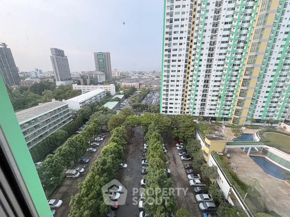 High-rise building with city view and parking area, showcasing urban living.