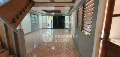 Spacious open-plan living area with tiled flooring and wooden accents