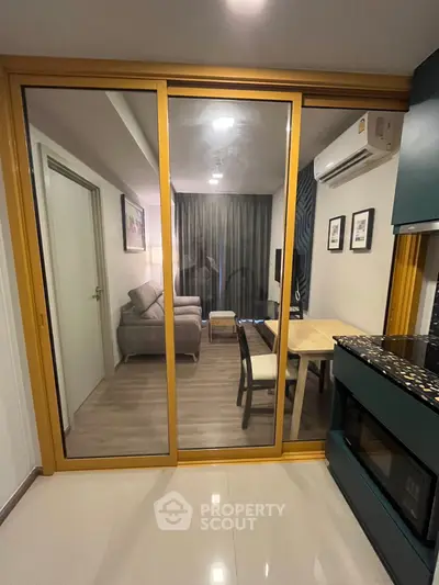 Modern apartment interior with glass sliding doors, cozy living area, and stylish kitchen.