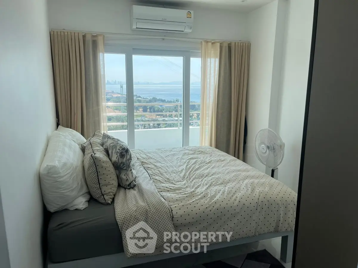 Cozy bedroom with ocean view and air conditioning in modern apartment.