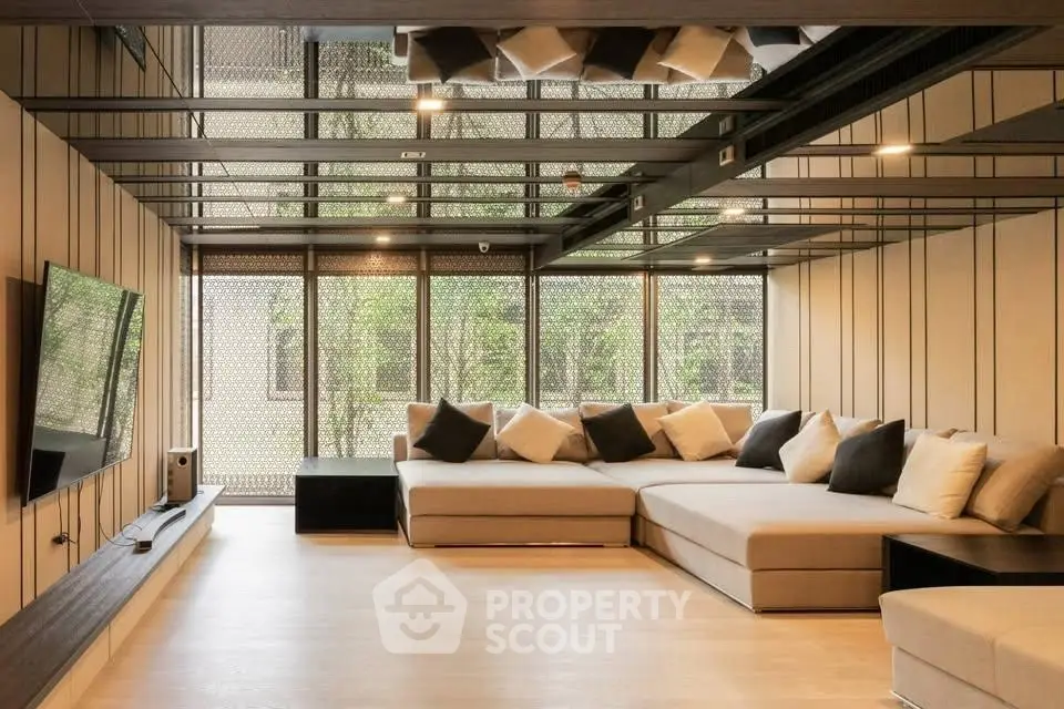 Luxurious modern living room with large sectional sofa and floor-to-ceiling windows.