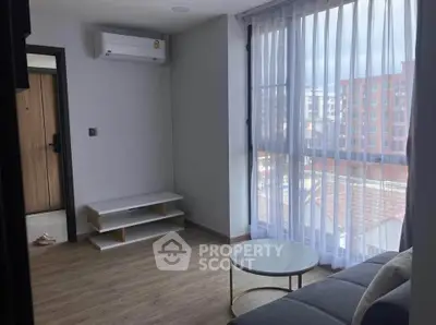 Modern living room with large window and air conditioning in urban apartment.