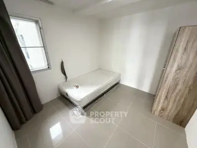 Minimalist bedroom with single bed and wardrobe, ideal for compact living spaces.