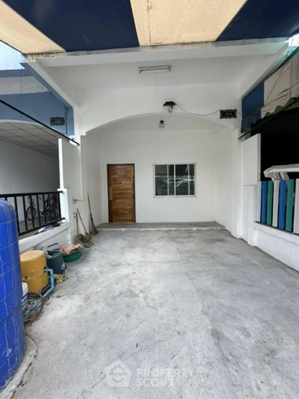 Spacious covered parking area with secure entrance and window view.