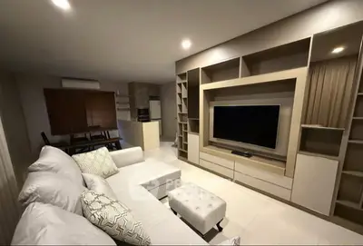 Modern living room with stylish built-in entertainment center and cozy sectional sofa.