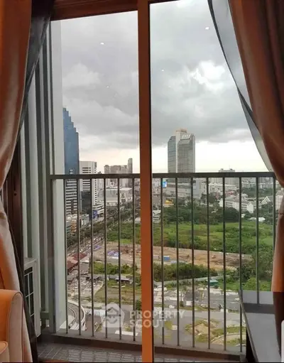 Stunning city view from high-rise apartment balcony with modern glass railing.