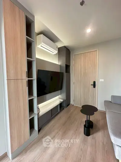 Modern living room with sleek furniture and wall-mounted TV in a stylish apartment.