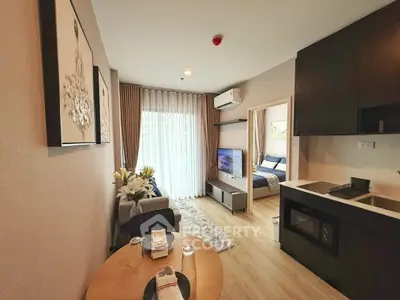 Modern open-plan living room with kitchen and bedroom view, featuring stylish decor and natural light.