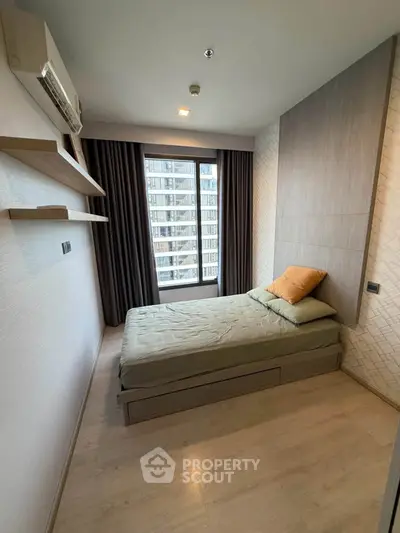 Modern bedroom with single bed, large window, and minimalist decor in urban apartment.
