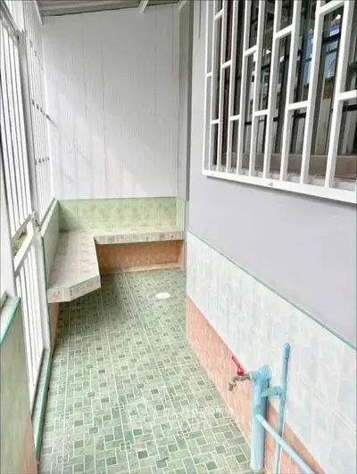 Charming tiled balcony with built-in seating and secure railing, perfect for relaxation.