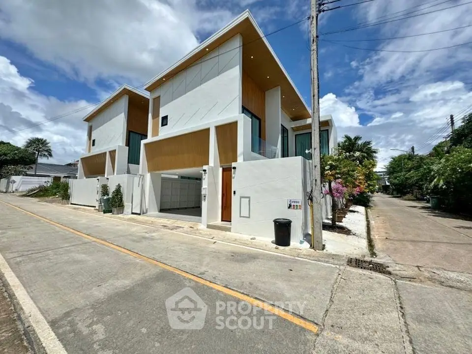 Modern architectural design of a contemporary townhouse with clean lines and spacious driveway.