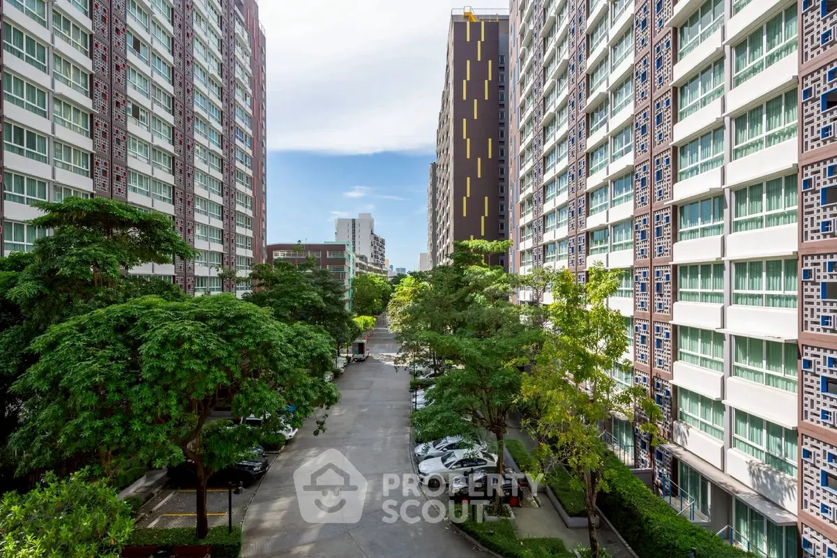 Stunning view of modern apartment buildings with lush greenery and ample parking space.