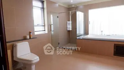 Spacious modern bathroom with glass shower and bathtub