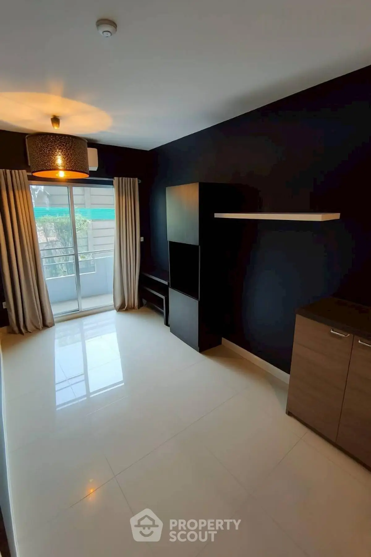 Spacious modern living room with balcony access and stylish lighting.