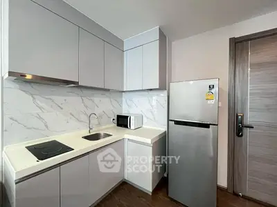 Modern kitchen with sleek cabinets, marble backsplash, and stainless steel appliances.