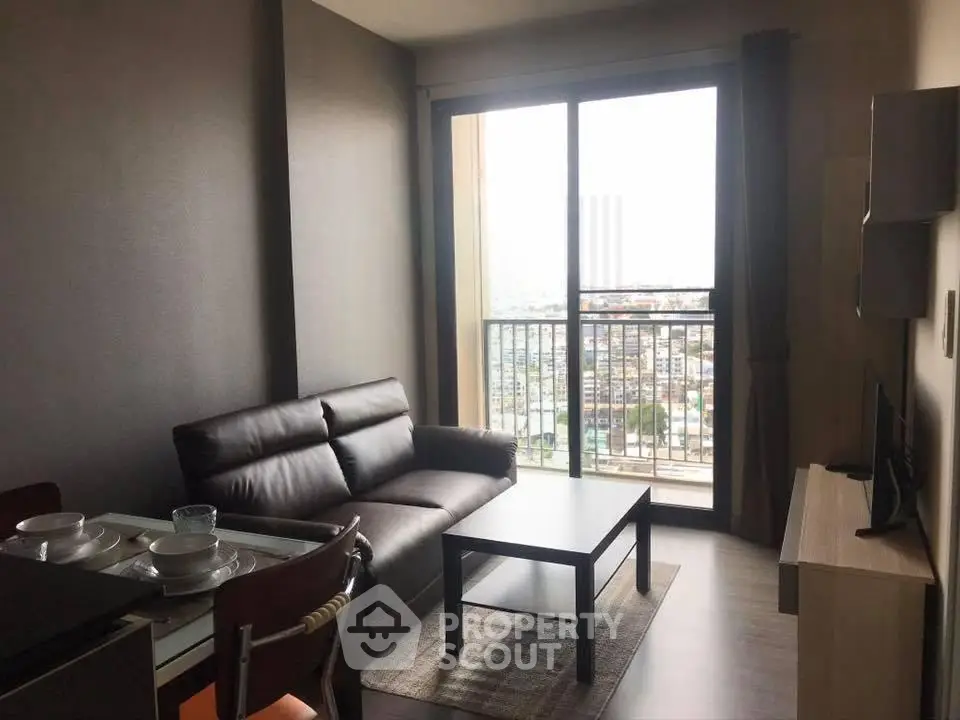 Modern living room with city view, featuring sleek furniture and large windows for natural light.
