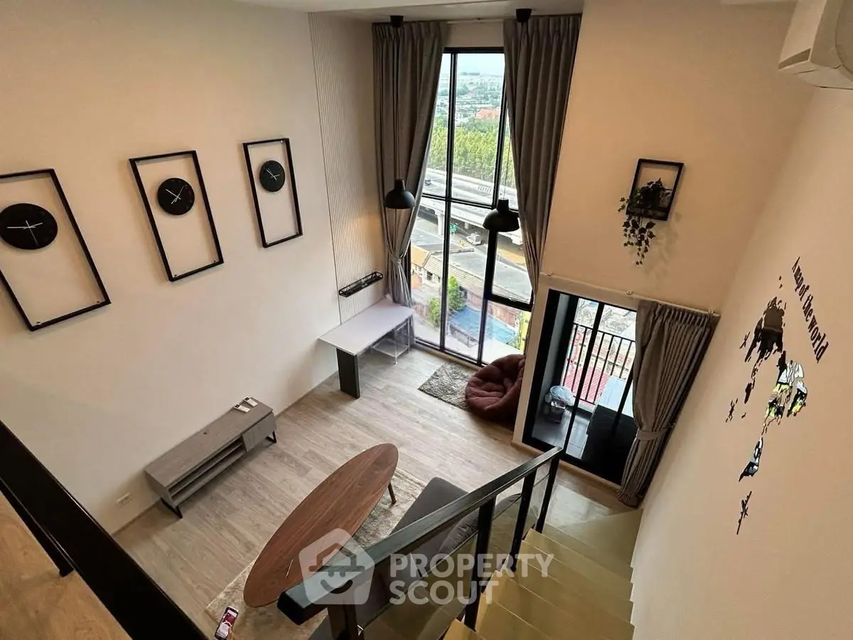 Modern loft-style living room with high ceilings and large windows offering stunning views.