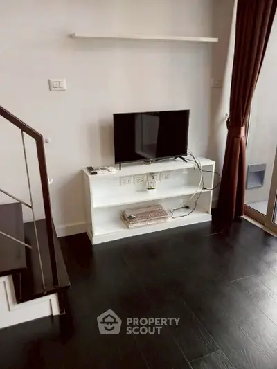 Modern living room with sleek TV stand and dark wood flooring