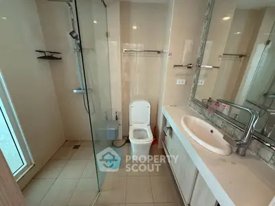 Modern bathroom with glass shower and sleek vanity in a contemporary home.
