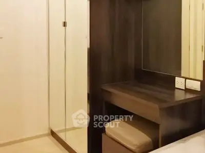 Modern bedroom with sleek mirrored wardrobe and compact vanity desk.