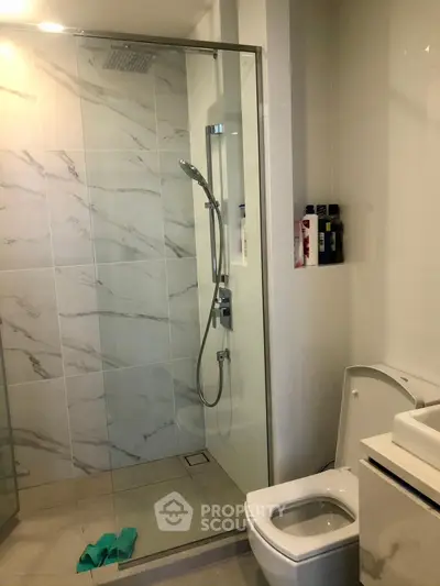 Modern bathroom with glass shower and marble tiles