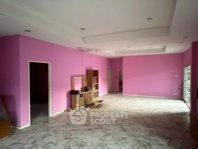 Spacious pink-walled room with marble flooring, ideal for creative interior design.