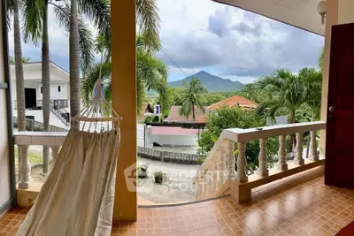 Charming balcony with hammock and scenic mountain view, perfect for relaxation in tropical setting.