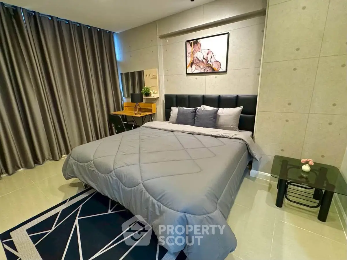 Modern bedroom with stylish decor, featuring a comfortable bed, sleek furniture, and elegant curtains.