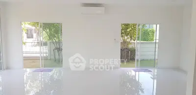 Spacious living room with large windows and garden view, perfect for natural light lovers.