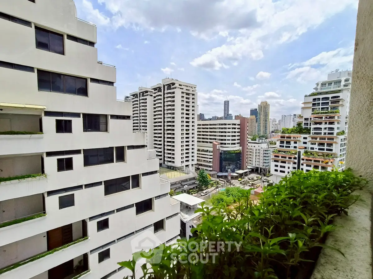 Stunning cityscape view from a high-rise balcony overlooking modern urban architecture.