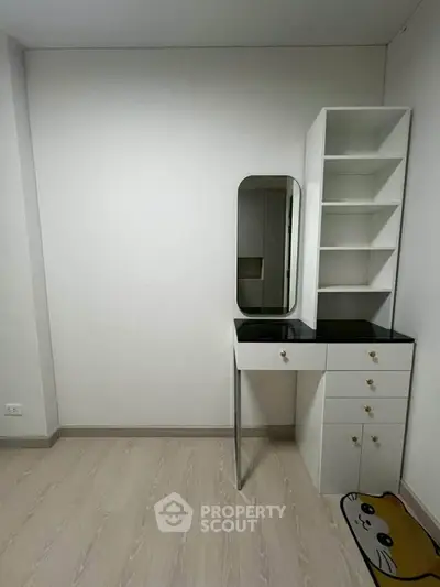 Minimalist study area with sleek desk and shelving in modern apartment.