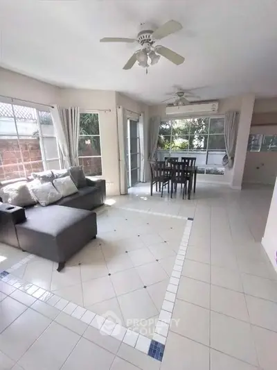 Spacious living room with large windows and modern furniture in a bright, airy home.