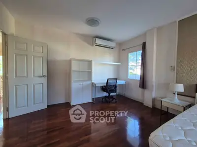 Spacious bedroom with hardwood floors and modern furniture