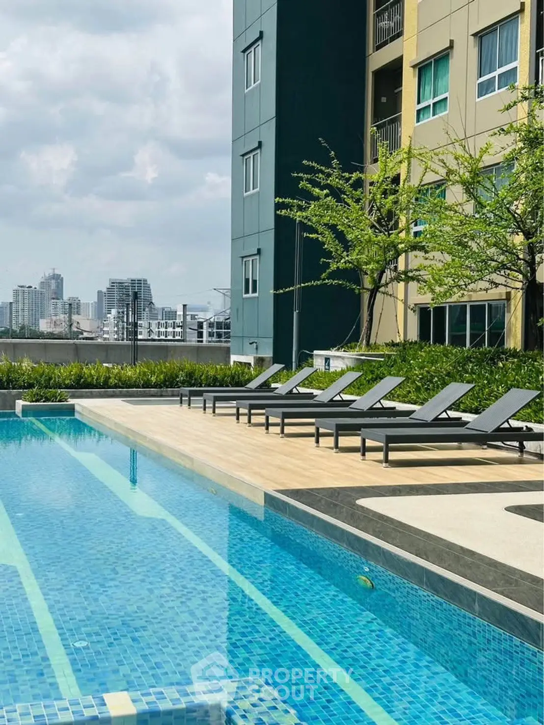 Luxurious apartment pool area with city skyline view, perfect for relaxation and leisure.