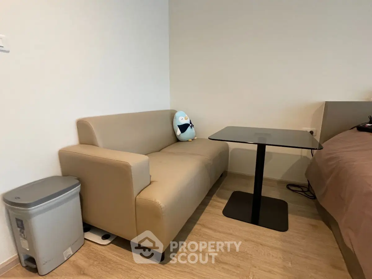 Cozy modern living space with beige sofa and sleek glass table, perfect for urban living.