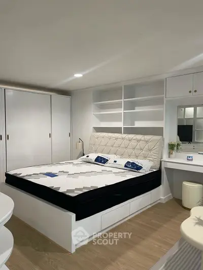 Modern bedroom with built-in storage and stylish decor, perfect for urban living.