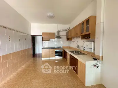 Spacious kitchen with modern cabinetry and tiled flooring in a bright open layout.