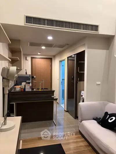 Modern compact apartment with open kitchen and cozy living area, featuring sleek design and efficient use of space.