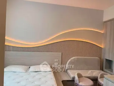 Modern bedroom with stylish wave lighting and cozy seating area