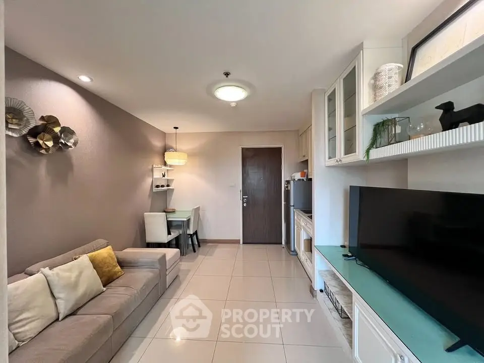 Modern living room with stylish decor and open layout, featuring a cozy sofa and sleek TV setup.