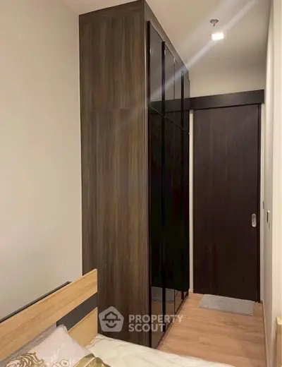 Modern bedroom with sleek wardrobe and wooden accents, perfect for urban living.