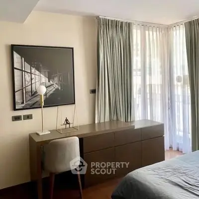 Modern bedroom with stylish decor and natural light, featuring a sleek desk and elegant curtains.