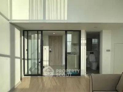 Modern apartment interior with sliding glass doors and wooden flooring