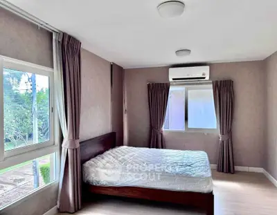 Spacious bedroom with large windows and air conditioning in modern home.