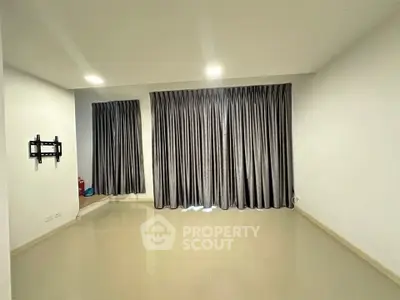 Spacious empty living room with elegant curtains and wall-mounted TV bracket